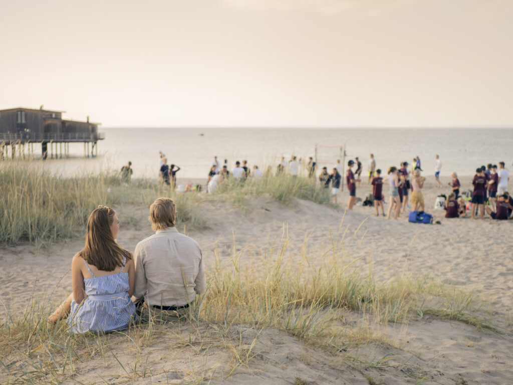 Par som sitter i sandynerna på Skansenbadet i Båstad.
